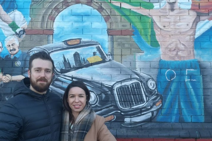 a man and a woman posing in front of a building