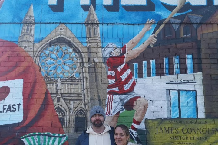 a person standing in front of a graffiti covered building