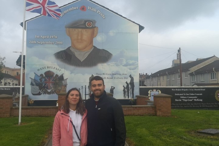 a person standing in front of a sign posing for the camera