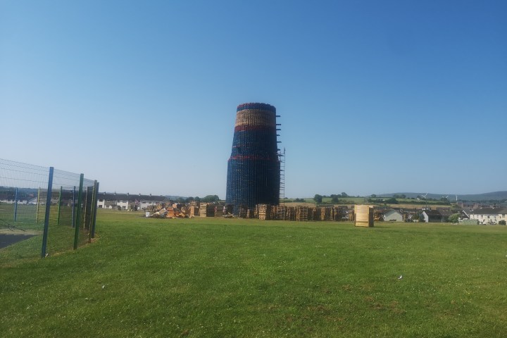 a large green field with trees in the background