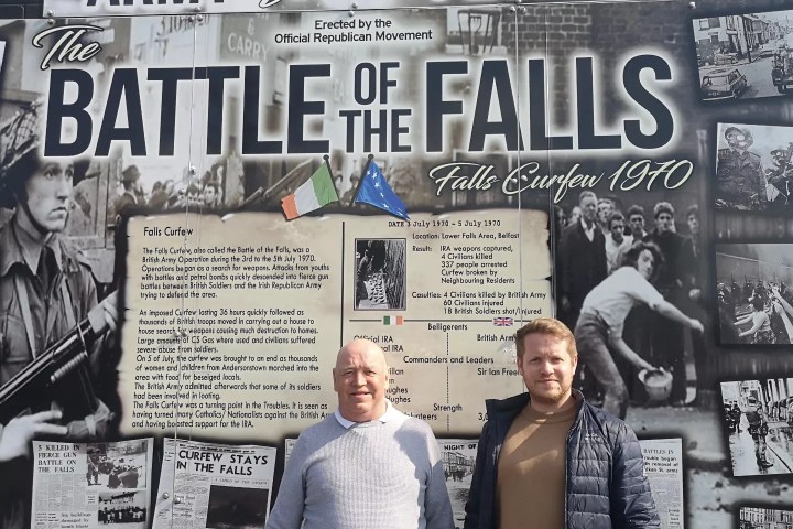 a group of people standing in front of a sign