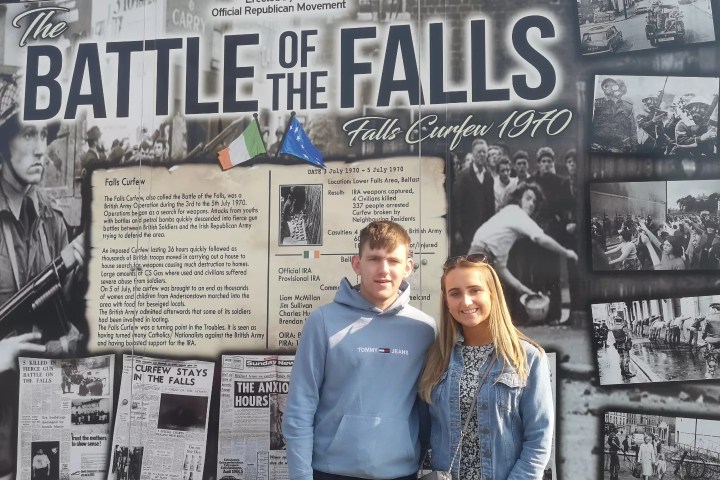a group of people standing in front of a newspaper