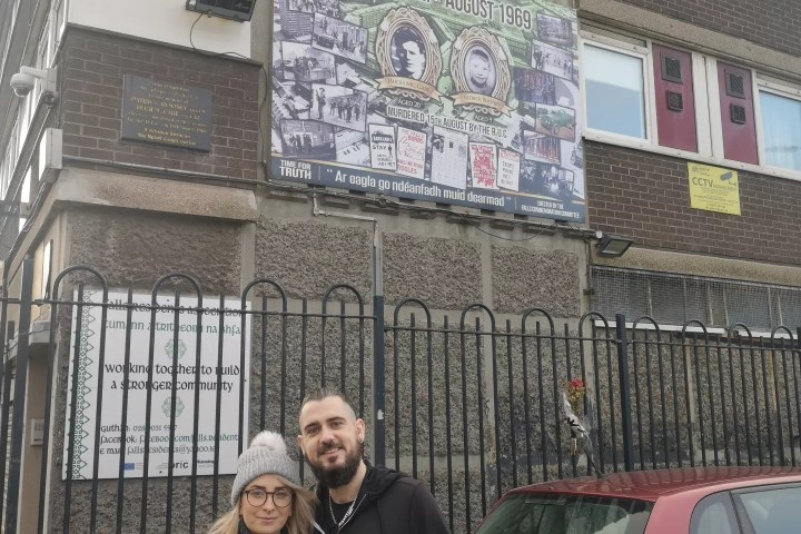 a group of people standing in front of a car posing for the camera